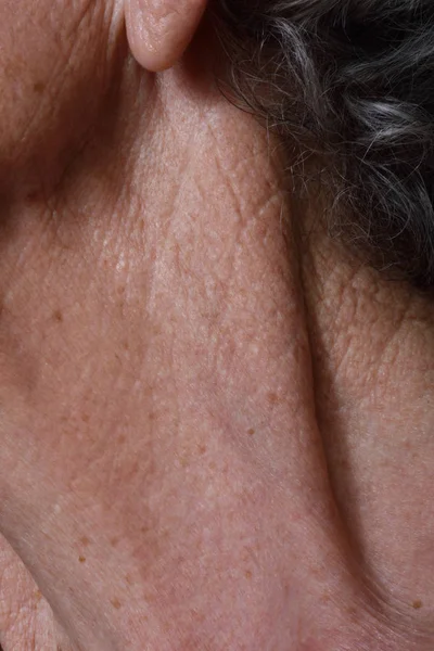 Морщины на шее пожилой женщины — стоковое фото