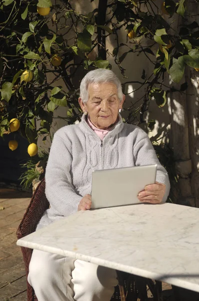 Oude vrouw met een tabel buiten — Stockfoto