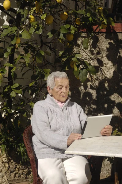 Ηλικιωμένη γυναίκα με ένα τραπέζι έξω από — Φωτογραφία Αρχείου