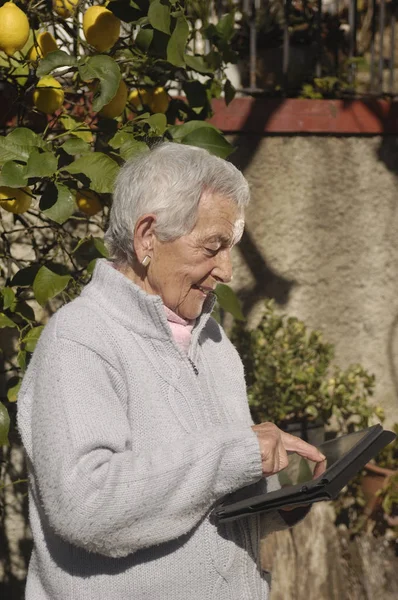 Oude vrouw met een tabel buiten — Stockfoto