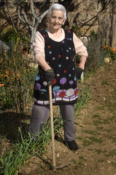 Mulher velha trabalhando em seu jardim — Fotografia de Stock