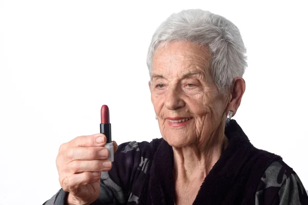 Mujer vieja pintando sus labios sobre fondo blanco — Foto de Stock