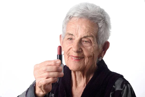 Vecchia donna che dipinge le labbra su sfondo bianco — Foto Stock