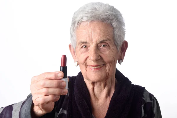 Стара жінка малює губи на білому тлі — стокове фото