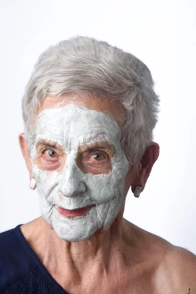 Старша жінка з фейковою маскою на білому — стокове фото