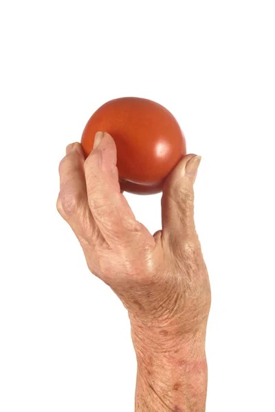 Ręka senior kobiety i pomidor na białym tle — Zdjęcie stockowe