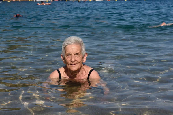 Starší žena se těší na pláž — Stock fotografie