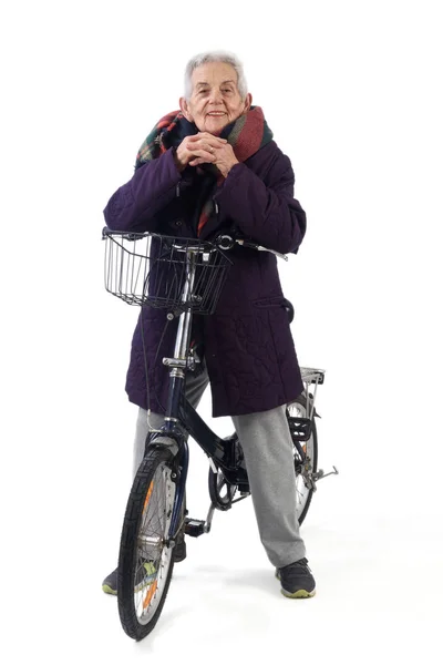 Senior woman posing with a bicycle on white background — Stock Photo, Image