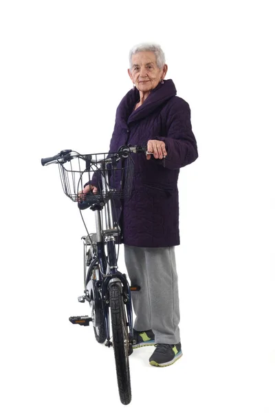 흰색 바탕에 자전거와 함께 포즈를 취하는 고위 여자 — 스톡 사진