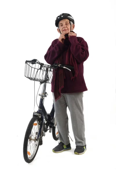 Mulher idosa em uma bicicleta em um fundo branco — Fotografia de Stock