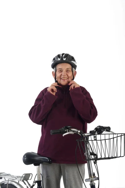 Mulher idosa em uma bicicleta em um fundo branco — Fotografia de Stock