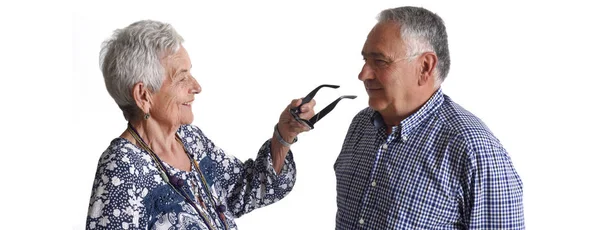Yaşlı bir adamın gözlük yaşlı bir kadın için koyarak — Stok fotoğraf