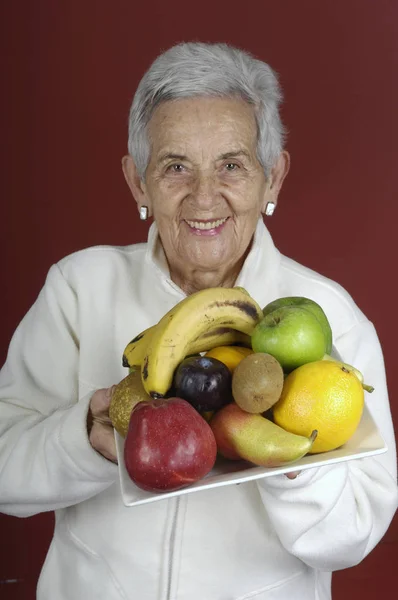 Äldre kvinna med frukt — Stockfoto