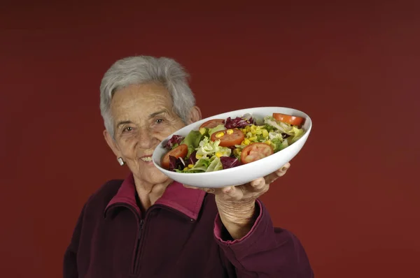 Äldre kvinna med sallad — Stockfoto