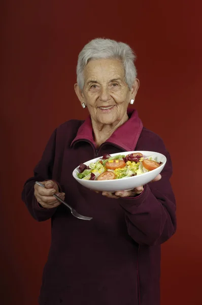 Äldre kvinna med sallad — Stockfoto