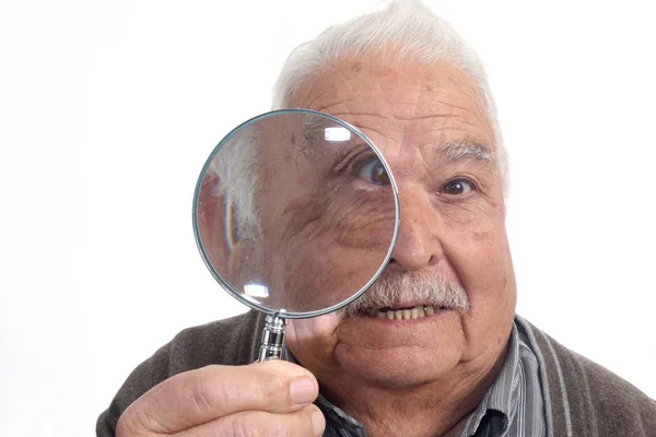 Nieuwsgierig man "peering" door vergrootglas — Stockfoto