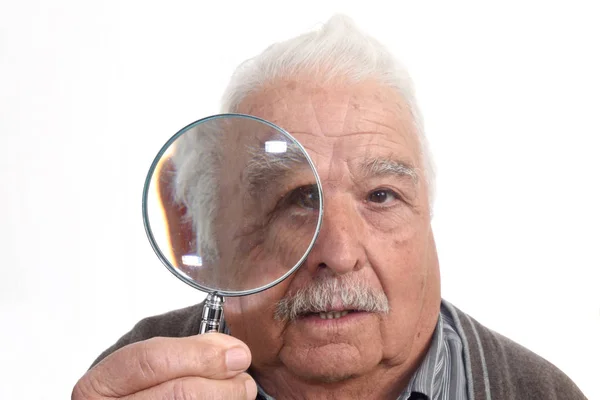 Nieuwsgierig man "peering" door vergrootglas — Stockfoto