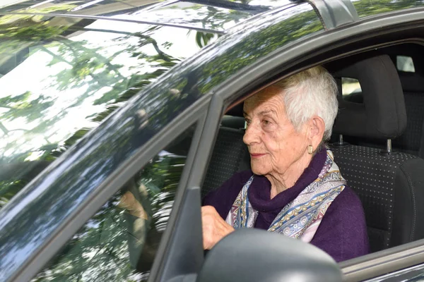 Seniorenvrouw in een auto — Stockfoto