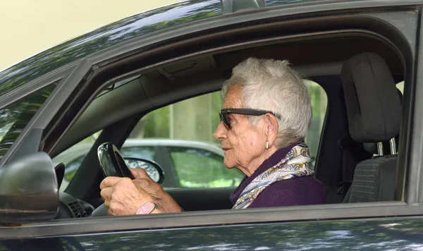 Seniorenvrouw in een auto — Stockfoto