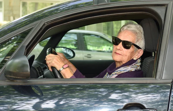 Seniorenvrouw in een auto — Stockfoto