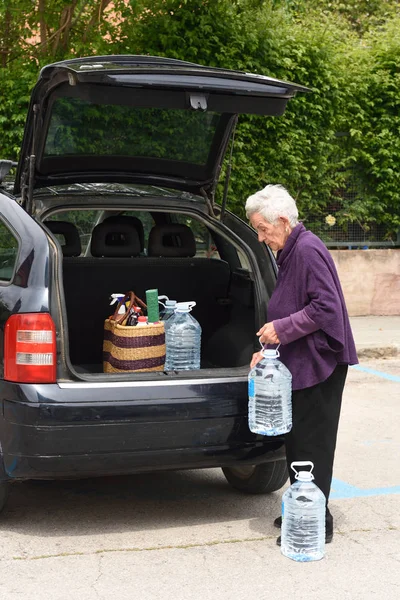 Anciana descargando la compra del coche — Foto de Stock