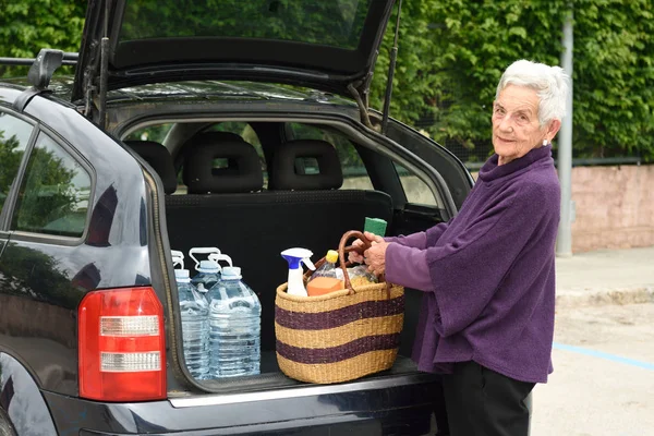 Anciana descargando la compra del coche — Foto de Stock