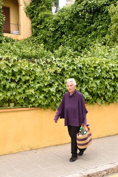 Een oudere vrouw die uit de winkel komt — Stockfoto