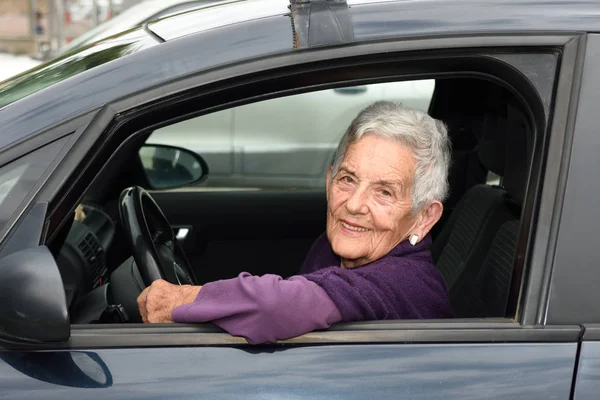 Seniorenvrouw in een auto — Stockfoto