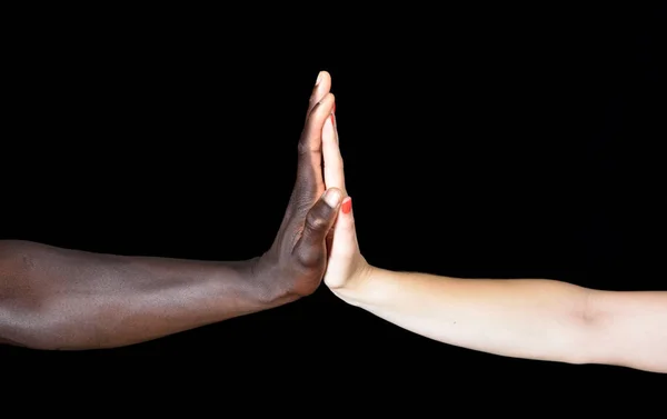 Manos de hombre negro y mujer blanca sobre fondo negro — Foto de Stock