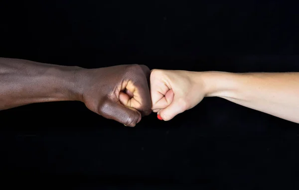 Eine Hand von schwarzem Mann und weißer Frau auf schwarzem Hintergrund — Stockfoto