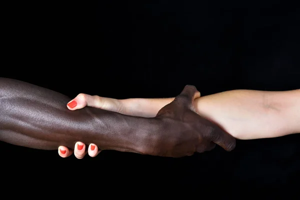 Eine Hand von schwarzem Mann und weißer Frau auf schwarzem Hintergrund — Stockfoto