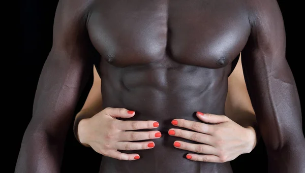 La mano di una donna bianca su una pancia muscolosa di un uomo nero — Foto Stock