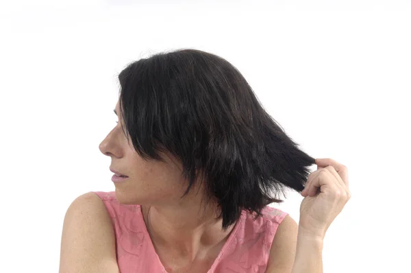 Mulher tocando seu cabelo no fundo branco — Fotografia de Stock