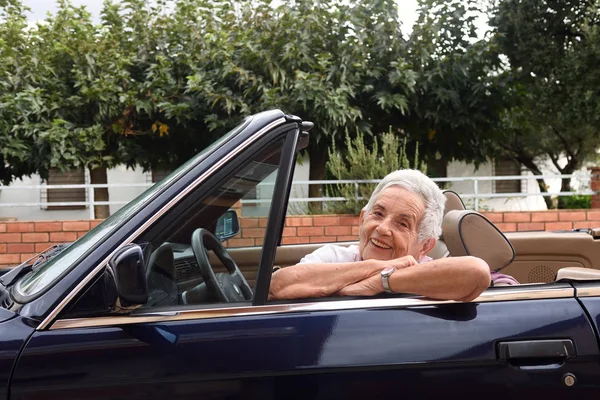 Portret van een senior vrouw met converteerbare auto — Stockfoto