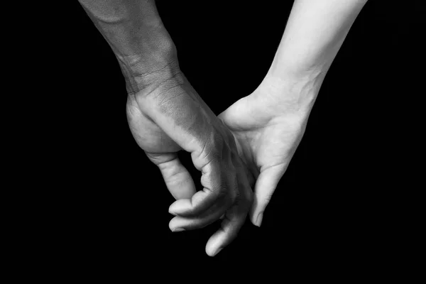 Eine Hand von schwarzem Mann und weißer Frau auf schwarzem Hintergrund — Stockfoto