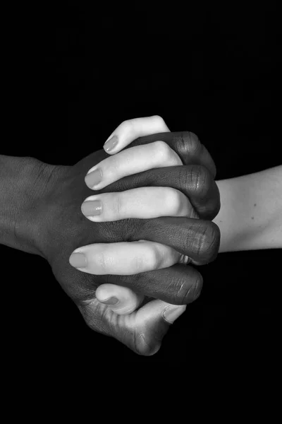 Manos de hombre negro y mujer blanca sobre fondo negro — Foto de Stock