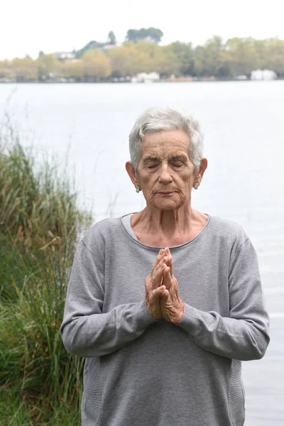 Oudere vrouw mediteren op de buitenkant — Stockfoto