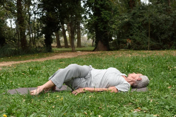 Oudere vrouw praktizerende yoga in het buitenland — Stockfoto