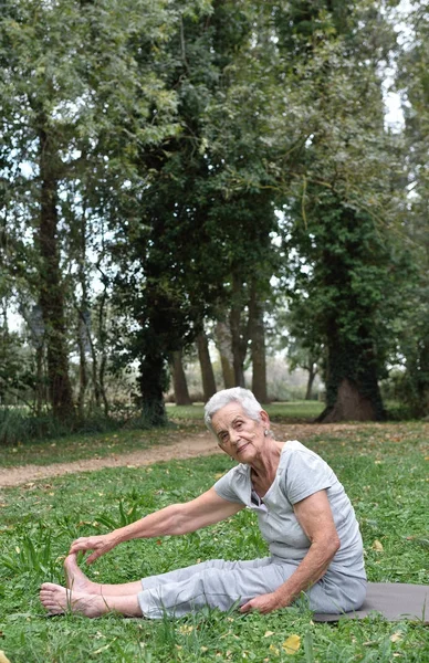 an older woman doing yoga outdoors