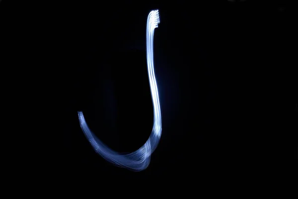 Siyah arka plan harf J ışık ile boya — Stok fotoğraf