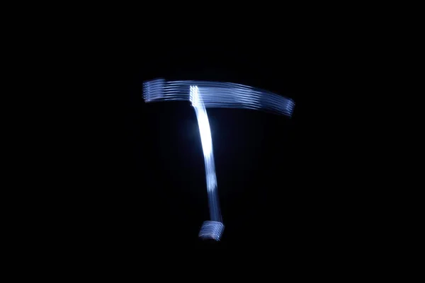 검은 배경 문자 T에 빛으로 페인트 — 스톡 사진
