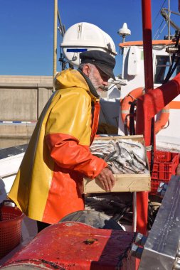 balıkçı bir balık kutusunun içinde bir balıkçı teknesi ile