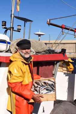 balıkçı bir balık kutusunun içinde bir balıkçı teknesi ile