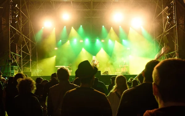 People silhouettes in front of bright stage lights, music