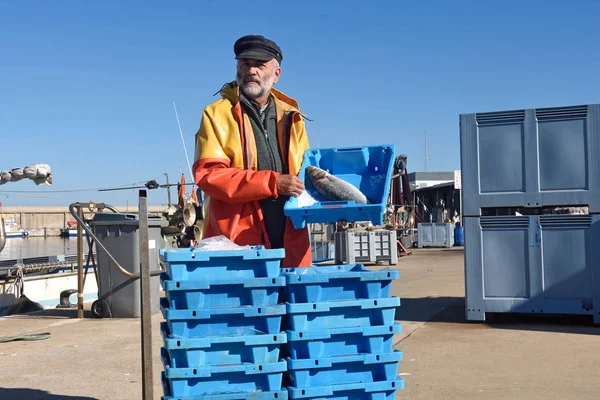 Pescatore con una scatola di pesce all'interno di una barca da pesca — Foto Stock