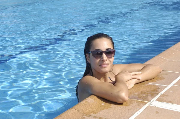 Mulher tomando banho de sol na piscina — Fotografia de Stock
