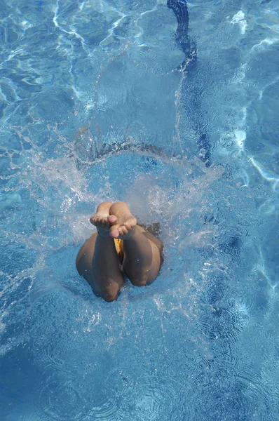 Mujer saltando en la piscina un día de verano — Foto de Stock