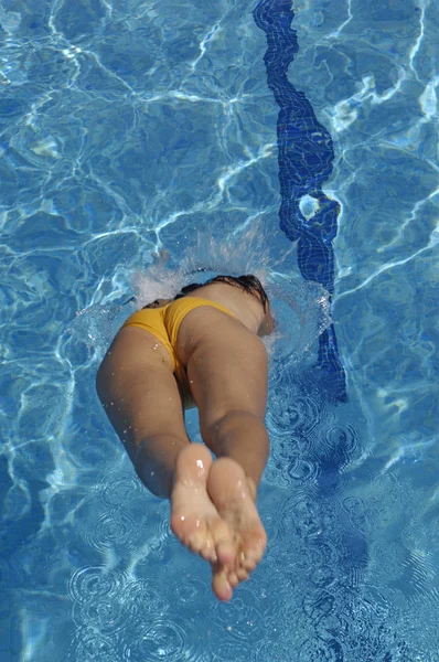 Mujer saltando en la piscina un día de verano —  Fotos de Stock