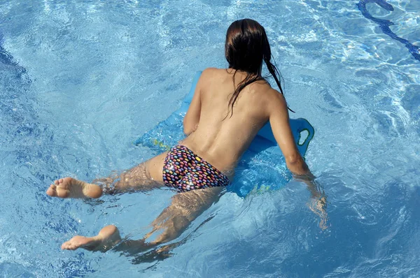 Жінка в басейні насолоджується літнім днем — стокове фото
