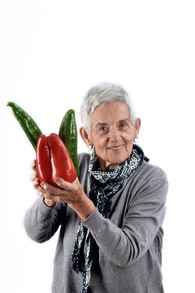 Idősebb nő, étkezési paprika, fehér — Stock Fotó